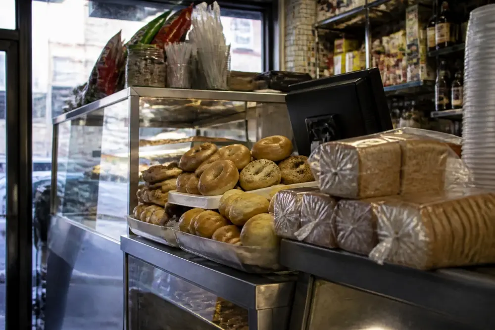 Bagels, rolls and sliced bread on a bodega counter